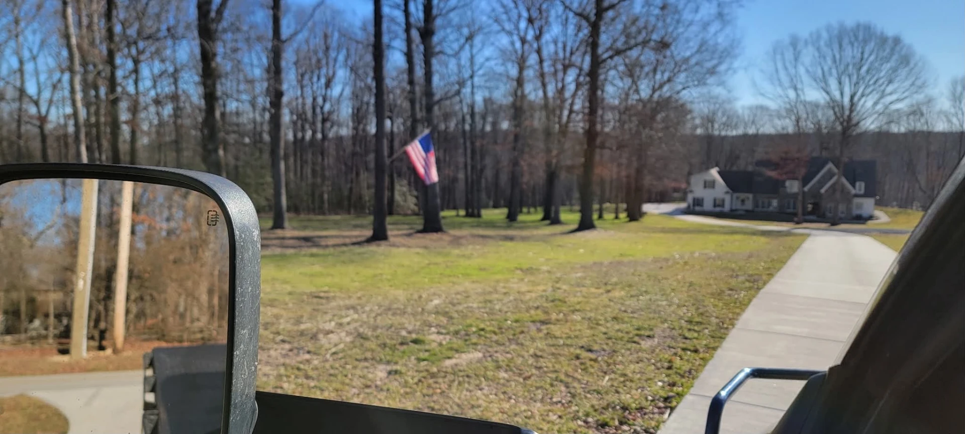 Freshly seeded lawn along a concrete driveway leading to a home