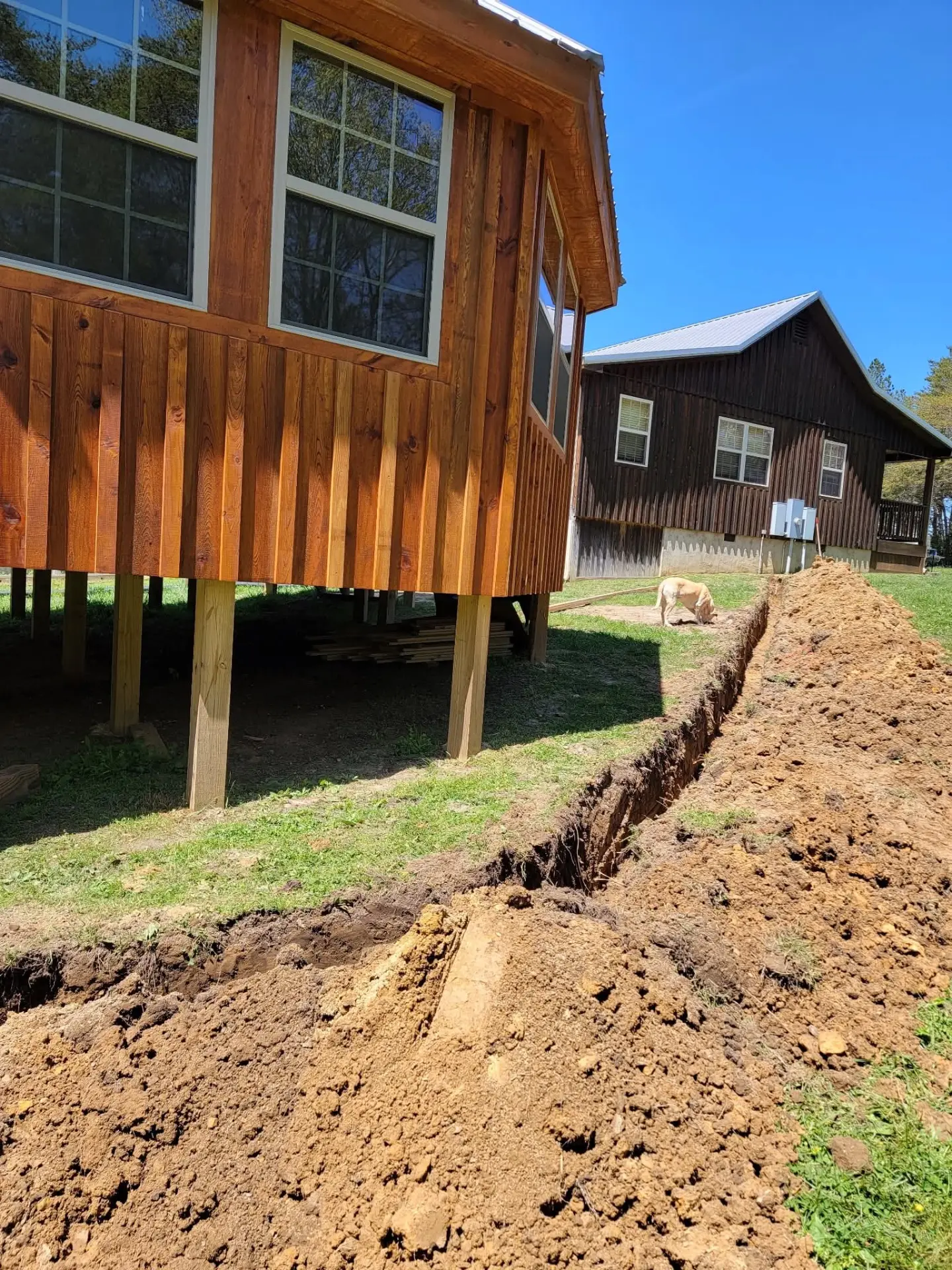 Trench running beside two wooden cabins