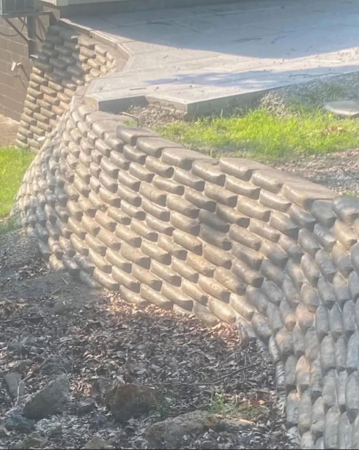 Curved stacked retaining wall along a driveway